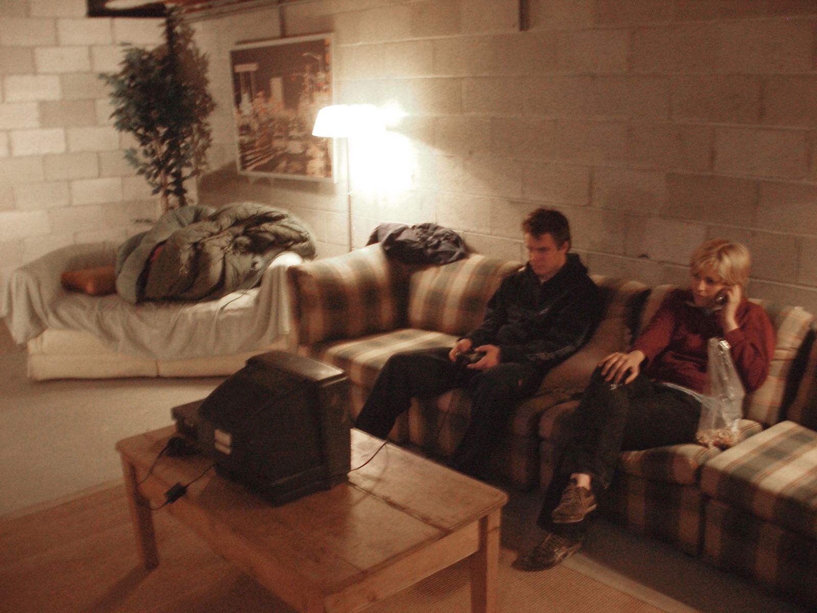Colin Bliss and Greta Scheing sit on a secondhand couch the group of eight artists snuck into their secret apartment in the Providence Place mall.