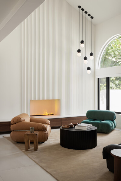 Integrated storage custom crafted with walnut lends warmth and texture to the water vapor fireplace and stark white fire surround.