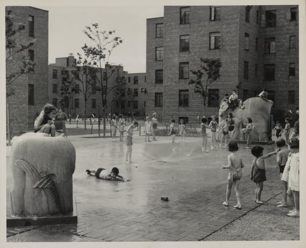Children playing in fountains and on animal sculptures in the courtyard of the Jane Addams Homes housing project.
