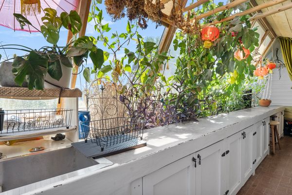 In addition to skylights, the split-level house has large slanted south-east-facing windows on each level, letting in plenty of light to grow plants.