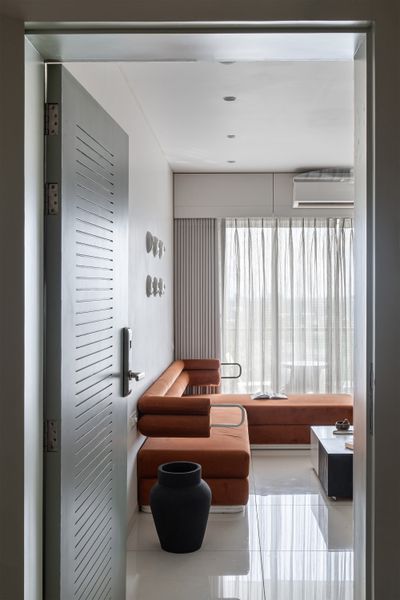 Located on the top floor of a 14-story apartment building, the home's living room extends onto a balcony, where the residents can socialize or drink their morning tea.
