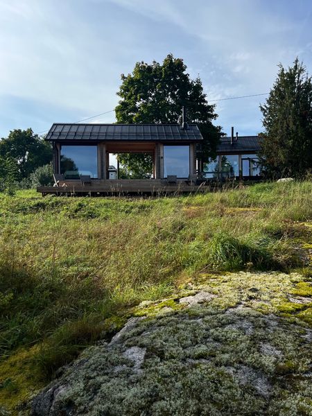 Looking back to the rear of the sauna and guest bedroom from the field. The large windows not only invite the view inside, but also reflect the landscape and allow the built forms to dissolve.