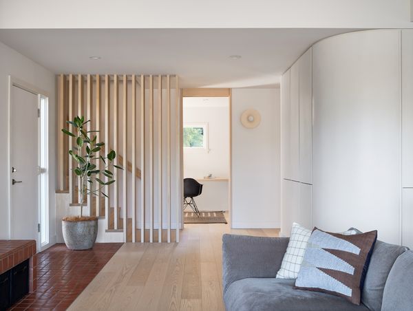 The portion of the bench that’s closer to the entryway has cubbies that were originally designed to store firewood, but now the homeowners use them to store baby toys adding yet more flexibility.