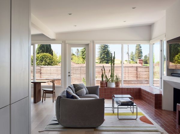 The tiled bench extends in front of the fireplace and down toward the entryway, creating a satisfying tie between the multiple different distinct areas of the open living space.
