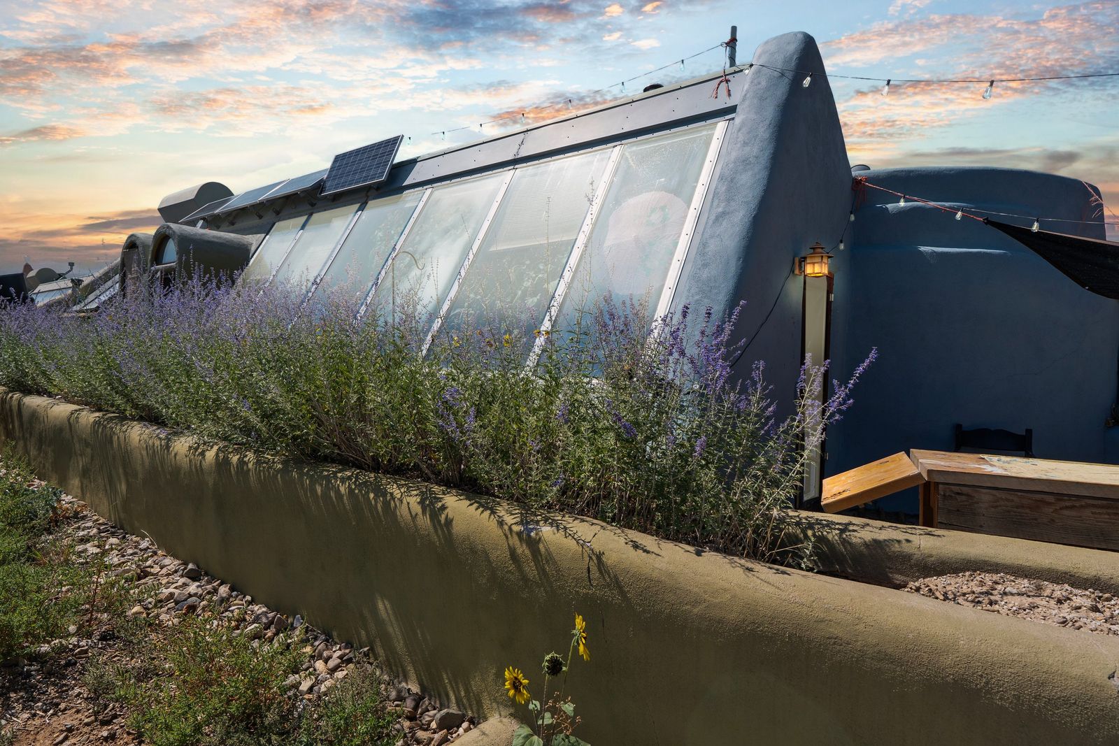 This funky New Mexico earthship home is powered by the sun and embedded in the land with curvaceous walls and lots of gardening space—inside and out.