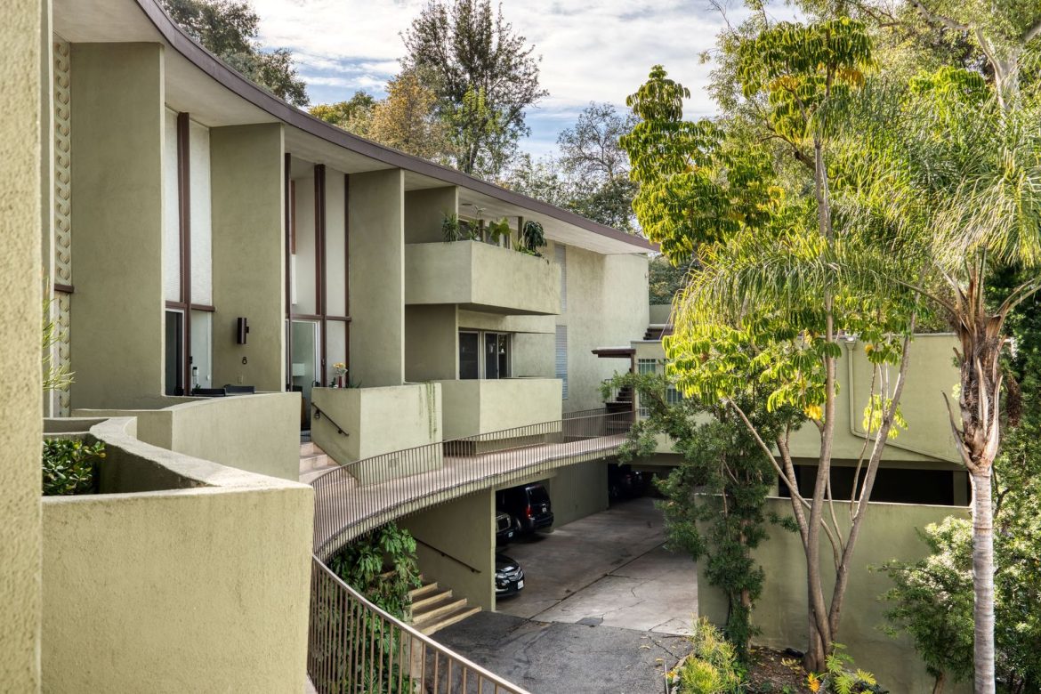 this-historic-two-story-condo-by-ray-kappe-has-double-height-windows-original-wood-paneling-and-three-separate-patios.jpg