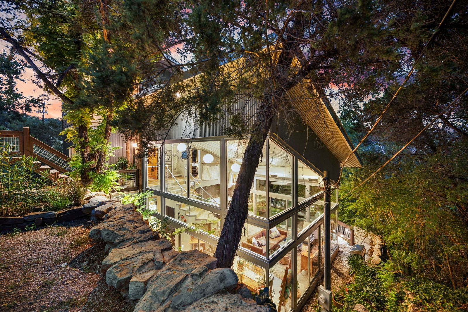 This metal-clad house makes the most of its lush surroundings with 30-foot-tall windows and ample outdoor space.