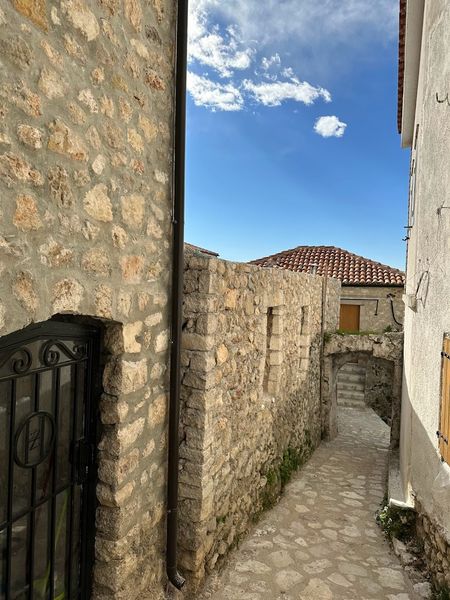 Unadorned stone walls naturally flow up from the walkway.