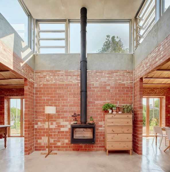The energy efficient design relies on a wood-burning stove for chilly days, otherwise sunlight, and operable windows and doors take care of most of the heating and cooling.